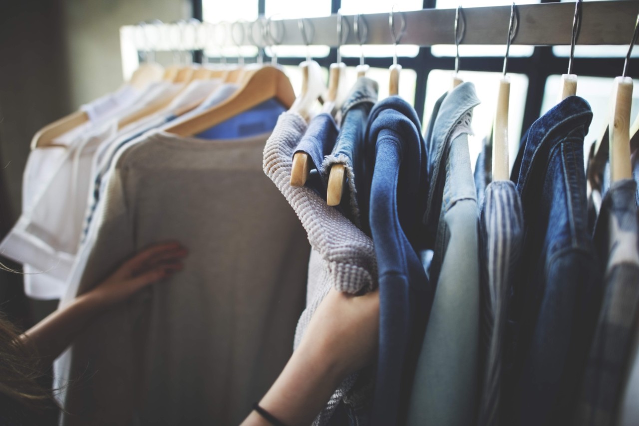 persoon die naar kleren op een stok kijkt